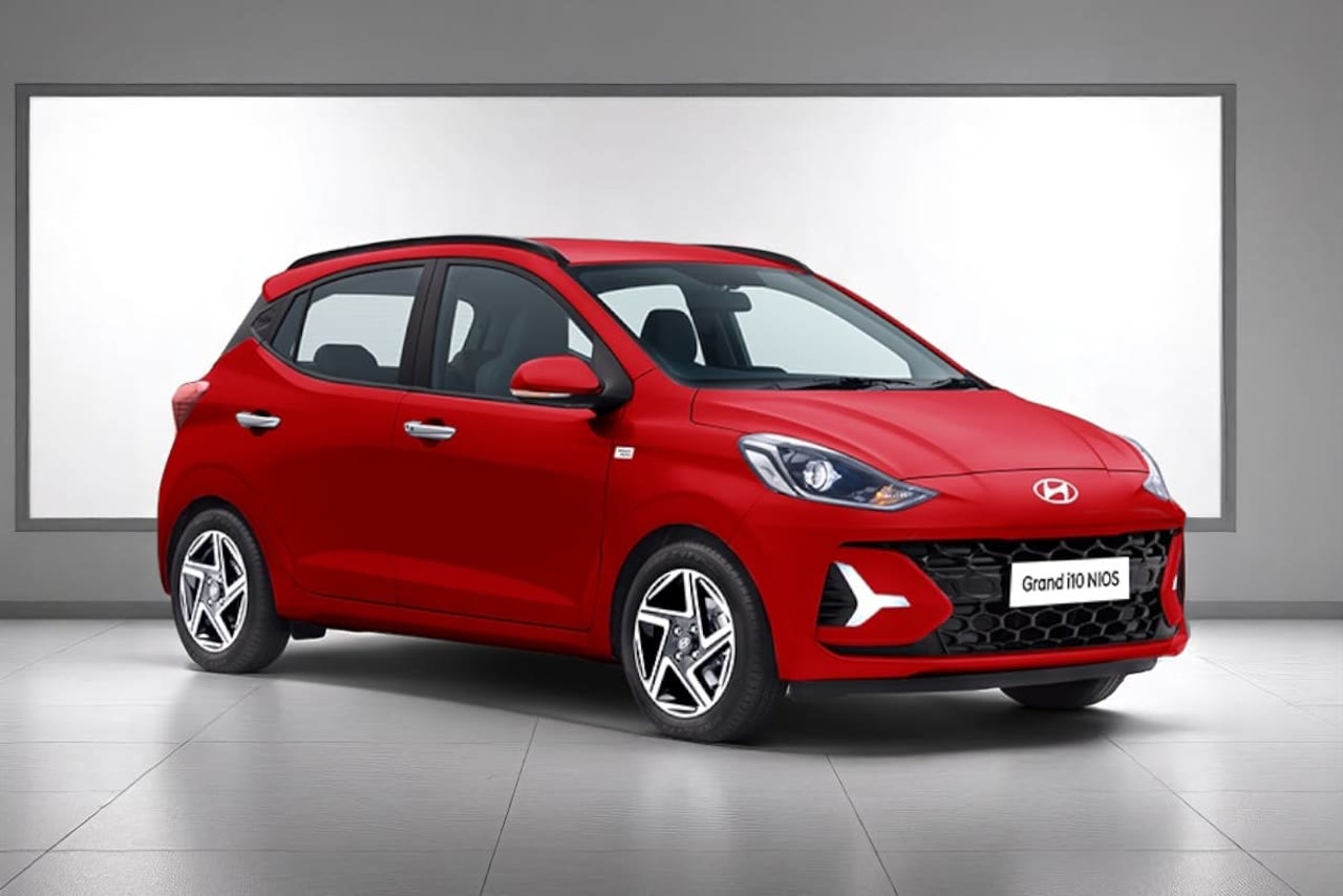Current India-spec Hyundai Grand i10 Nios facelift in Fiery Red, front three-quarter studio