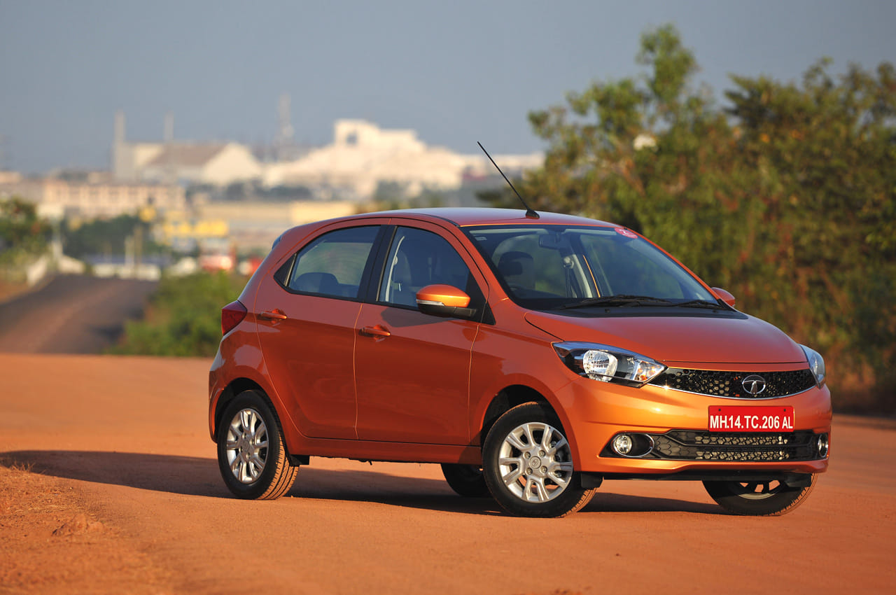 Original India-spec Tata Tiago (2016 pre-facelift), Sunburst Orange, OEM press front three-quarter